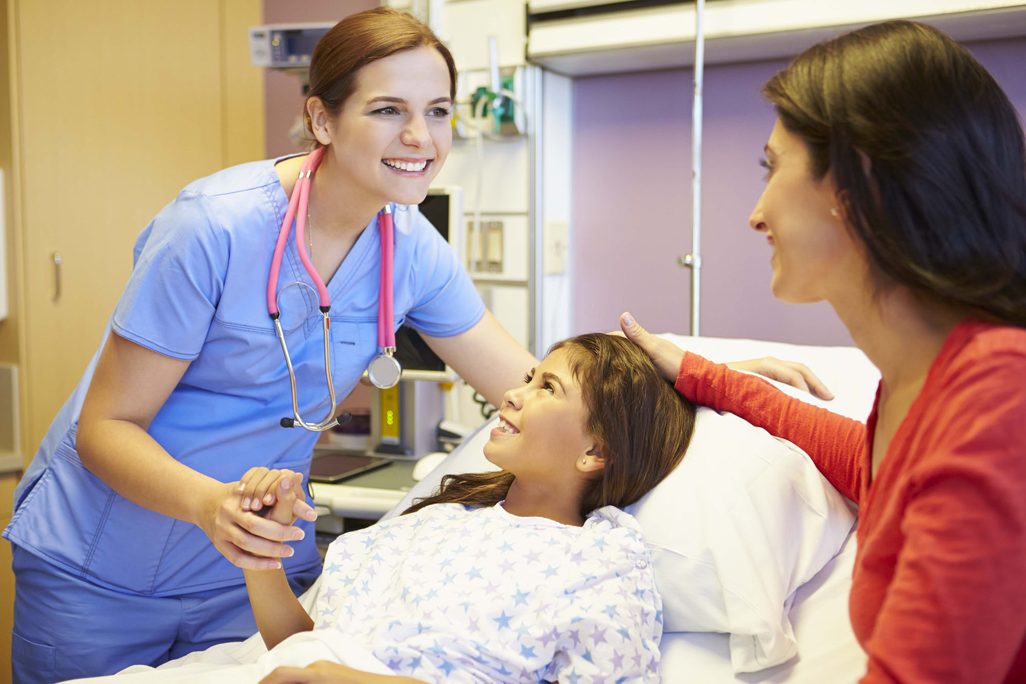 nurse holding child's hand and smiling at mother